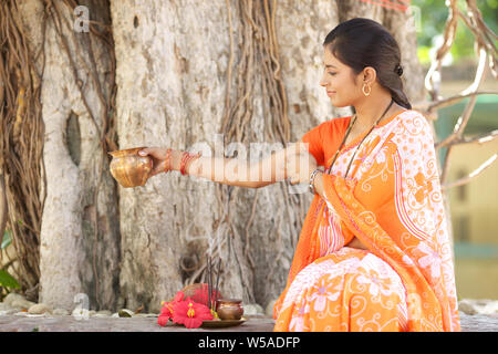 Donna adorare un albero sacro Foto Stock