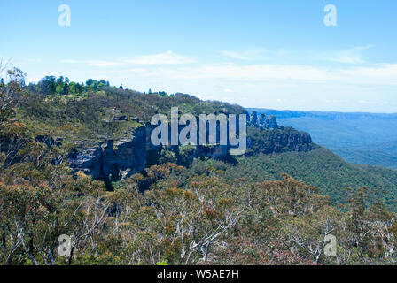 Valle di eucalipto tra intervalli rocciosa a montagne blu Foto Stock