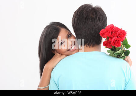 Giovane che abbraccia ogni altra e sorridente Foto Stock