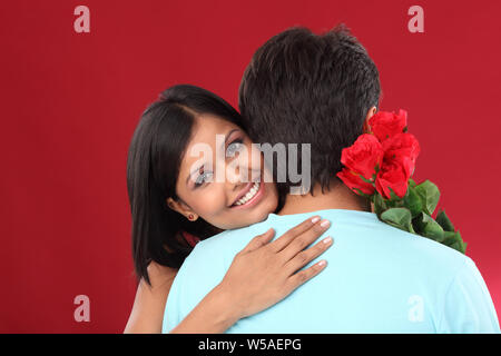 Giovane che abbraccia ogni altra e sorridente Foto Stock
