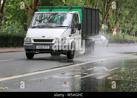 Londra, UK 27 Luglio 2019 - un furgone di spruzzi di acqua quando si aziona attraverso un alluvione sulla Green Lanes nel nord di Londra, causato dalla pesante acquazzone durante la notte. Credito: Dinendra Haria/Alamy Live News Foto Stock