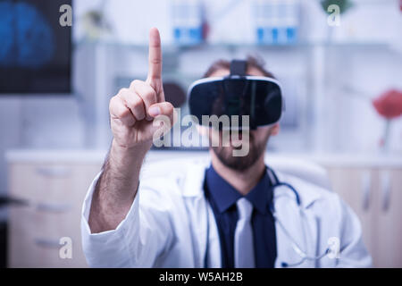 In ambienti chiusi immagine ravvicinata del giovane maschio medico indossando occhiali per realtà virtuale. La moderna tecnologia utilizzata in hospita. Foto Stock