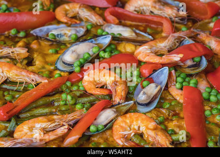 Spagnolo paella di pesce in padella con cozze, gamberi e verdure. Frutti di mare sullo sfondo di paella vicino fino Foto Stock