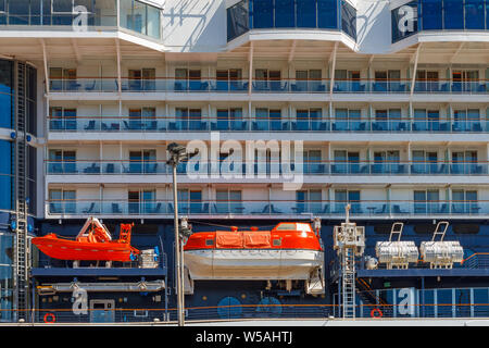 Ci sono quattro imbarcazioni di salvataggio arancione sul bordo della nave da crociera. A otto piani nave da crociera con imbarcazioni di salvataggio arancione è nel porto di Koper, Slovenia Foto Stock