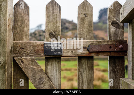 Immagine ravvicinata di un cancello chiuso che smette di pecore passando attraverso che dice Stock a pascolare sulla parte anteriore Foto Stock