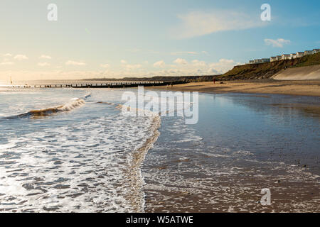 Hornsea Beach shot presto su una mattina di sole con il caravan park a destra e una bassa marea a sinistra. Foto Stock