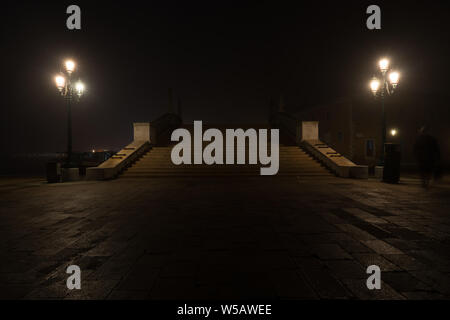 Ponte di Venezia di notte, una persona è in ombra precipita attraverso la scena. Foto Stock