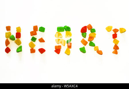 La parola cuore è steso con colorato canditi di frutta secca Foto Stock