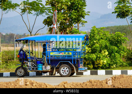 Chiangrai, Tailandia - 18 Feb 2018: blu vintage TukTuk è stato parcheggiato di fianco alla strada e atteso per il passeggero di fronte al lato del Laos. Chiangrai Thailandia. Foto Stock