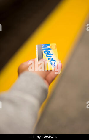 NEW YORK, Stati Uniti d'America - 27 agosto 2017: MetroCard nella mano di un giovane uomo a New York alla metropolitana. MetroCard è il metodo di pagamento per la metropolitana di New York Foto Stock