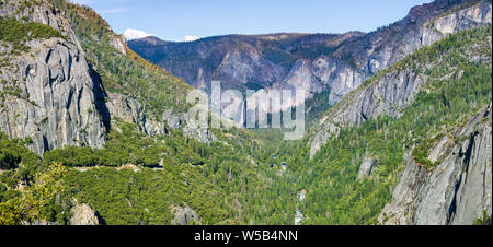 Vista di Yosemite Valley con fiume Merced fluente attraverso foreste sempreverdi e Bridalveil Falls visibile in background; il Parco Nazionale di Yosemite, si Foto Stock