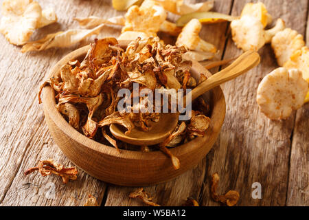 Essiccato wild finferli close-up su in una ciotola di legno sul tavolo orizzontale. Foto Stock