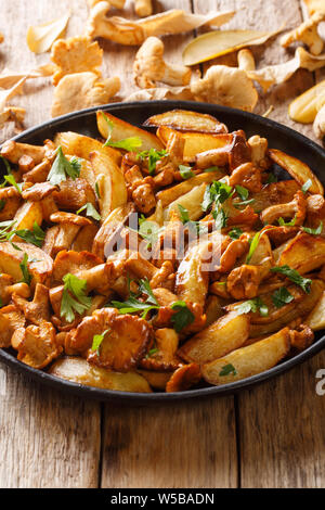 Patate fritte cunei selvaggio con finferli close-up su una piastra sul piano verticale. Foto Stock