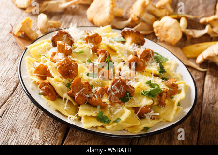 Ravioli fatti in casa con fried finferli e parmigiano closeup su una piastra sul tavolo orizzontale. Foto Stock