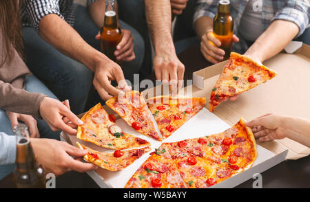 Gruppo di amici condividendo la pizza insieme al partito di casa