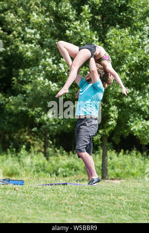Un giovane uomo solleva una donna sopra la sua testa come si pratica un impegnativo di routine nel vecchio quarto Ward Park il 19 maggio 2018 in Atlanta, GA. Foto Stock