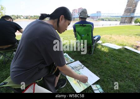 Cincinnati, Ohio, Stati Uniti d'America. Il 27 luglio 2019. (190727) -- Cincinnati (USA), 27 luglio 2019 (Xinhua) -- artisti cinesi che prendono parte a Cincinnati/vernice Liuzhou fuori programma schizzo a Smale Riverfront Park di Cincinnati di Ohio, negli Stati Uniti, 25 luglio 2019. Cinese e artisti degli Stati Uniti ha recentemente preso parte al Cincinnati/vernice Liuzhou fuori programma, in cui artisti del sud della Cina di Guangxi Zhuang Regione Autonoma sono stati invitati a visitare il sito web di Cincinnati per una settimana. Hanno visitato i musei e le gallerie di arte scambiate opinioni e tecniche con le loro controparti degli Stati Uniti, e ha presentato una mostra collettiva. Foto Stock