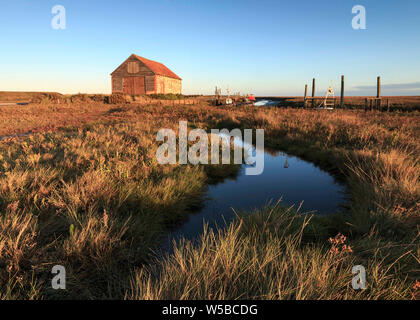 Vecchio Boathouse sul Salt Marsh nel porto vecchio di Thornham Regno Unito Foto Stock