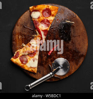 Alcune fette di salsiccia per pizza pizza sul tagliere di legno Foto Stock