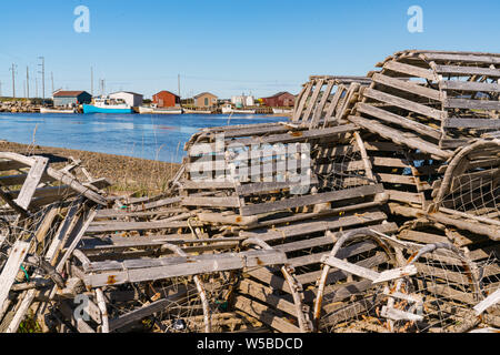 In legno antico trappole a base di aragosta e barche da pesca in un villaggio di pescatori nelle acque di Terranova, del Canada Foto Stock