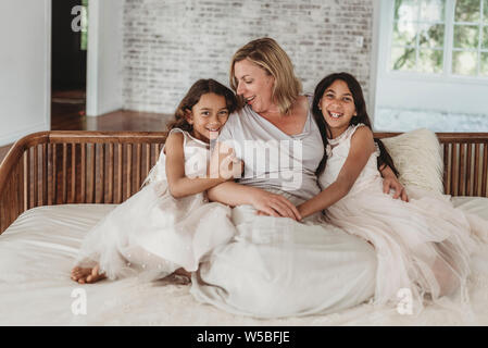 Ritratto di madre e le sue due figlie sul lettino di luce naturale e in studio Foto Stock