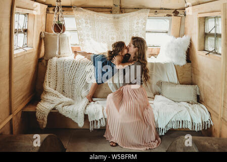 Madre e figlia baciare in boho configurazione studio Foto Stock