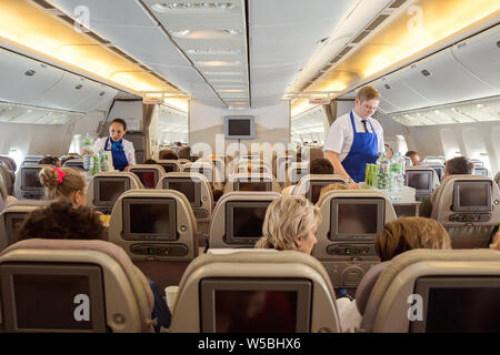 Volo San Pietroburgo - Bourgas - Giugno 24, 2019: Steward e hostess Iraero compagnie aeree servono i passeggeri su un volo charter, offrendo bevande analcoliche Foto Stock