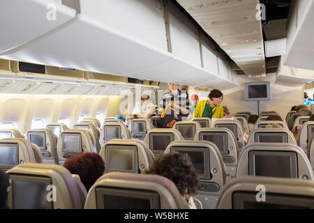 Pulkovo Aeroporto Internazionale, San Pietroburgo, Russia - 24 Giugno 2019: i passeggeri di salire a bordo. Le persone entrano in classe economica di cabina e di prendere i loro pl Foto Stock