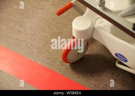 Arras, Hautes-de-France/France-March 10 2019: close up di un ospedale di Gurney gruppo ruota sulla pavimentazione di linoleum di corridoio Foto Stock