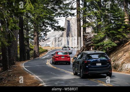 Giugno 27, 2019 il Parco Nazionale di Yosemite / CA / STATI UNITI D'AMERICA - vetture la guida verso il ghiacciaio Punto nel Parco Nazionale di Yosemite; mezza cupola visibile in background Foto Stock