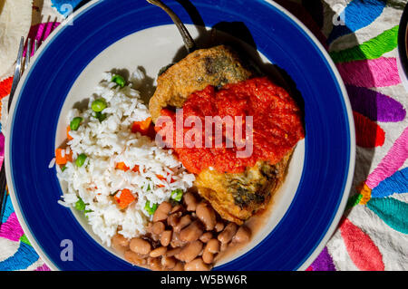 Mexican peperoncini ripieni (Chiles Rellenos), peperoncino poblano ripieni di formaggio e rivestito con una pastella di luce. Servito con fagioli, riso e pomodoro rosso s Foto Stock