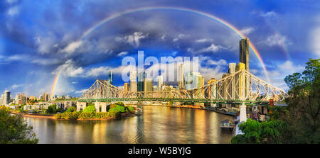 Lucky rainbow arco città di Brisbane CBD alti torri sulle rive del fiume Brisbane in morbido panorama liscio durante la mattina calda ora dopo ra freschi Foto Stock