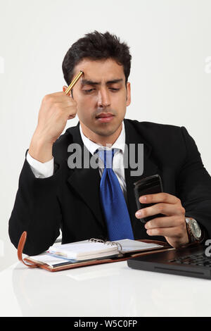 Uomo d'affari che lavora in ufficio e messaggistica di testo Foto Stock