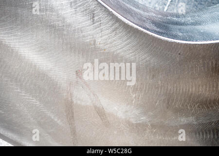 Background siver spazzola metallica in acciaio inox superficie della piastra con i contrassegni di bush e mette in evidenza Foto Stock