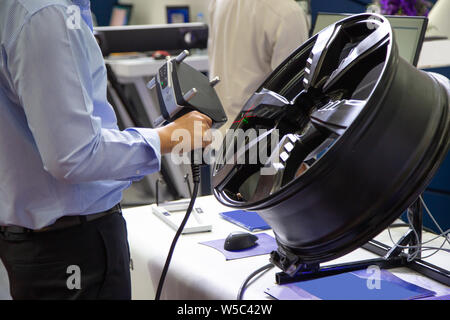 Lavoratore del settore utilizzare il palmare scanner 3D ispezione di una ruota Foto Stock
