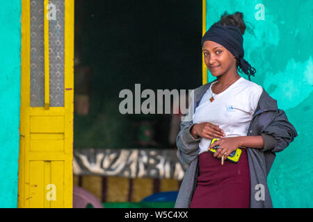 Una giovane donna pone al di fuori della sua casa per una fotografia, Debre Berhan, Etiopia. Foto Stock