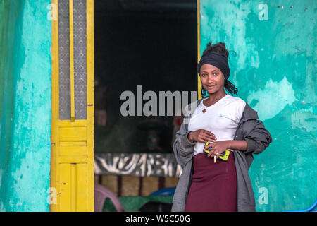 Una giovane donna pone al di fuori della sua casa per una fotografia, Debre Berhan, Etiopia. Foto Stock