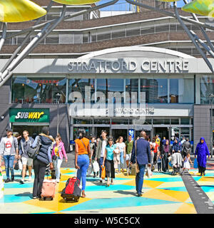 Diversi gruppi di persone su occupato attraversamento pedonale strada in colori luminosi links Stratford Shopping Center & stazioni & Westfield negozi East London REGNO UNITO Foto Stock