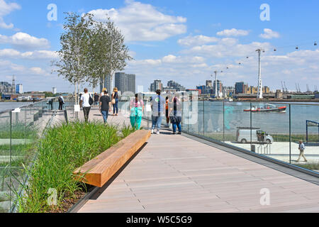 La gente che camminava la marea di ponti di parchi lineari links Fiume Tamigi riverside con elevati passeggiate intorno alla penisola di Greenwich nel Sud di Londra Inghilterra REGNO UNITO Foto Stock