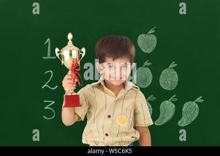 Ritratto di uno scolaro tenendo un trofeo Foto Stock