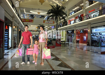 Famiglia con borse shopping in un centro commerciale Foto Stock