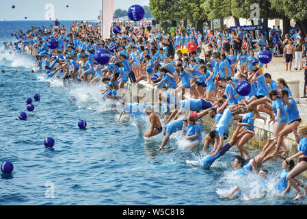 (190728) -- Pechino, 28 luglio 2019 (Xinhua) -- persone tuffarsi nel mare Adriatico durante il XIII DM Millennium Jump evento in Zadar, Croazia, il 27 luglio 2019. Più di 3 mila persone hanno partecipato alla manifestazione di quest'anno. (Foto di Dino Stanin/Xinhua) Foto Stock