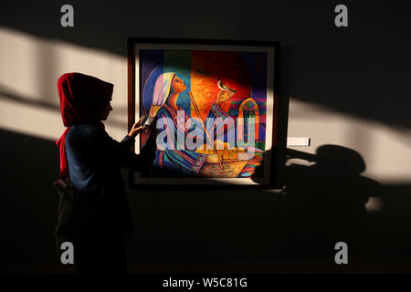 (190728) -- Pechino, 28 luglio 2019 (Xinhua) -- Un visitatore prende le foto di un dipinto da un artista Palestinese durante una mostra nella città di Gaza, 27 luglio 2019. Circa 64 artisti hanno presentato le loro opere alla mostra d'arte. (Str/Xinhua) Foto Stock