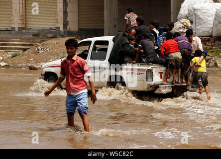 (190728) -- Pechino, 28 luglio 2019 (Xinhua) -- un auto corre in alluvioni dopo forti piogge in Sanaa, Yemen, luglio 26, 2019. Le forti piogge e inondazioni frequentemente colpiscono molti governorates in Yemen questa estate. (Foto di Mohammed Mohammed/Xinhua) Foto Stock