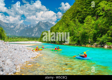Interessante il rafting e il kayak località. Active kayakers pagaiando sul colore smeraldo Soca river, nei pressi di Bovec, il Parco Nazionale del Triglav, Slovenia, Euro Foto Stock