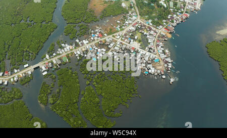 Città in zone umide e mangrovie sulla costa dell'oceano vista aerea. Siargao island, Filippine. Foto Stock