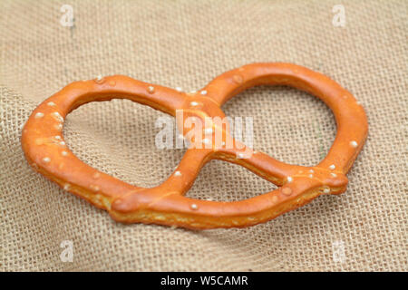 Unico pretzel croccanti su tela su tavola Foto Stock