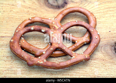 Una coppia di dischi pretzel sul tavolo di legno Foto Stock