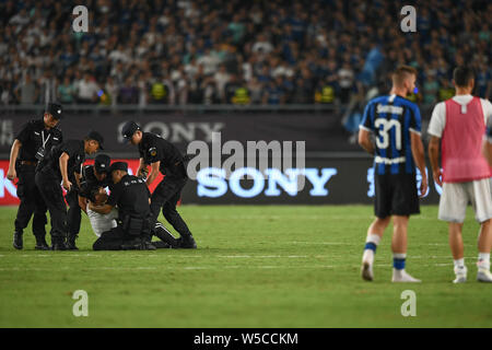 Un ventilatore adorante è azionato fuori dalla sicurezza dei membri del personale durante il 2019 International Champions Cup torneo di calcio tra Juventus F.C. e Inter nella città di Nanjing East cinese della provincia di Jiangsu, 24 luglio 2019. Foto Stock