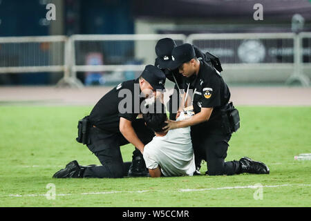Un ventilatore adorante è azionato fuori dalla sicurezza dei membri del personale durante il 2019 International Champions Cup torneo di calcio tra Juventus F.C. e Inter nella città di Nanjing East cinese della provincia di Jiangsu, 24 luglio 2019. Foto Stock